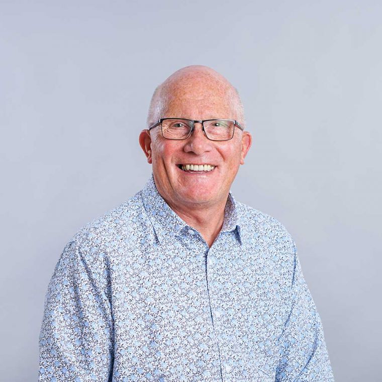 Portrait image of frank marsh smiling in a patterned shirt.